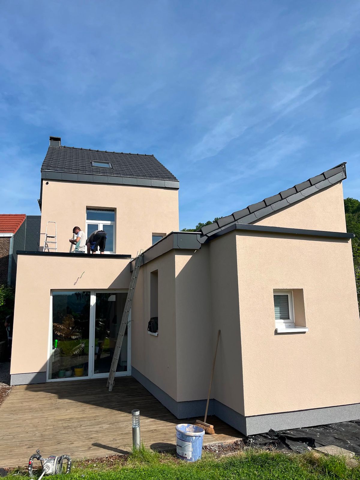 Façade de villa rénovée avec de grandes ouvertures vitrées